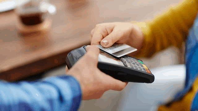 a person is paying with a credit card on a credit card machine .