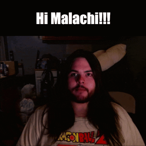 a man with long hair is wearing a dragon ball shirt
