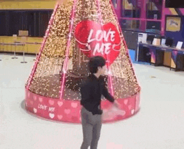 a man is standing in front of a valentine 's day display on a rink .