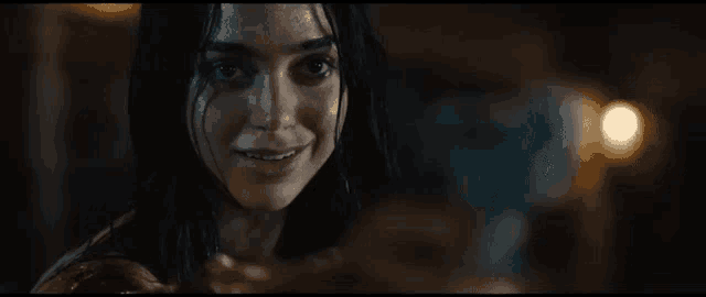 a close up of a woman 's face in a dark room smiling