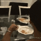 a person is sitting at a table eating a plate of food