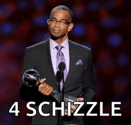 a man in a suit and tie holds a trophy in front of a microphone with the words 4 schizzle behind him