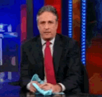 a man in a suit and tie is sitting at a desk