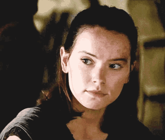 a close up of a woman 's face with a black shirt on