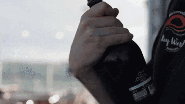 a person is holding a bottle of key west beer