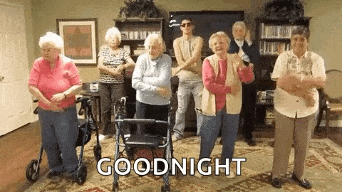 a group of elderly people are standing in a living room dancing .