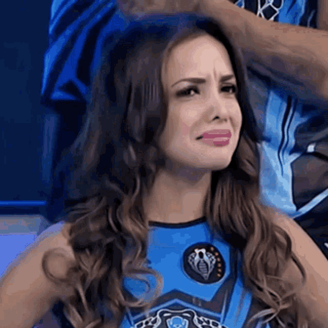 a woman is making a funny face while wearing a blue outfit .