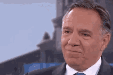 a close up of a man in a suit and tie making a funny face .