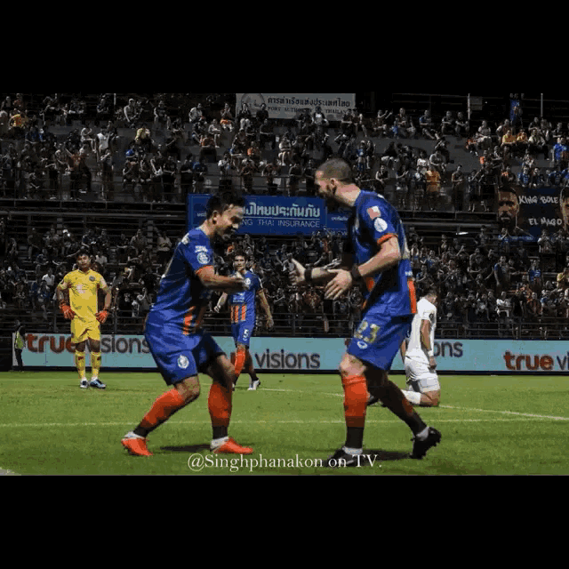 two soccer players on a field with a banner that says true vision