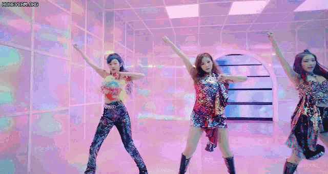 a group of girls are dancing in a room with a colorful background .
