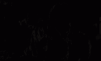 a woman with long dark hair is standing in a dark room looking down .