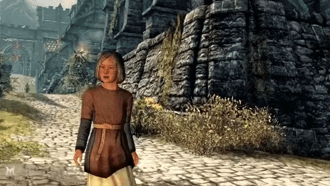 a girl in a brown shirt is walking down a cobblestone path