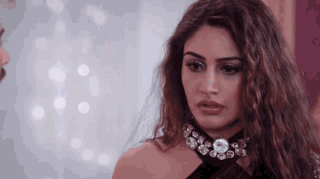 a close up of a woman wearing a choker and looking at a man .