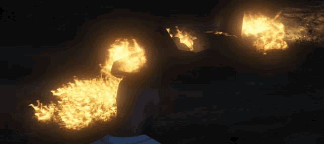 a person is standing in the dark with flames coming out of their hand