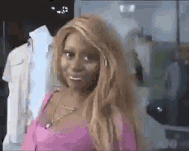 a woman with long blonde hair is standing in front of a mannequin in a store .