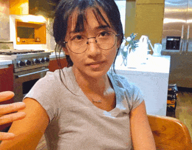 a woman wearing glasses and a necklace that says " i love you "