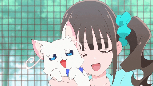 a girl is holding a white cat with a blue bow in her hair