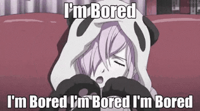 a girl in a panda costume is laying on a bed and making a heart shape with her hands .