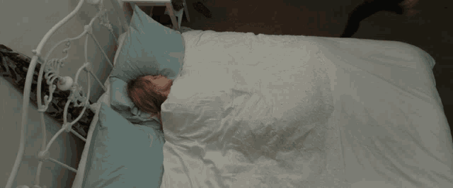 a woman in a black dress is laying on a bed next to a woman sleeping