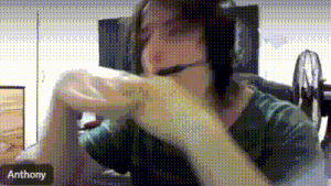 a man wearing headphones and a headset is sitting in front of a fan and talking on a video call .