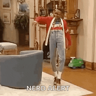 a woman is dancing in a living room with the words `` nerd alert '' written below her .