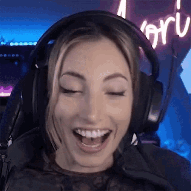 a woman wearing headphones is smiling with her mouth open