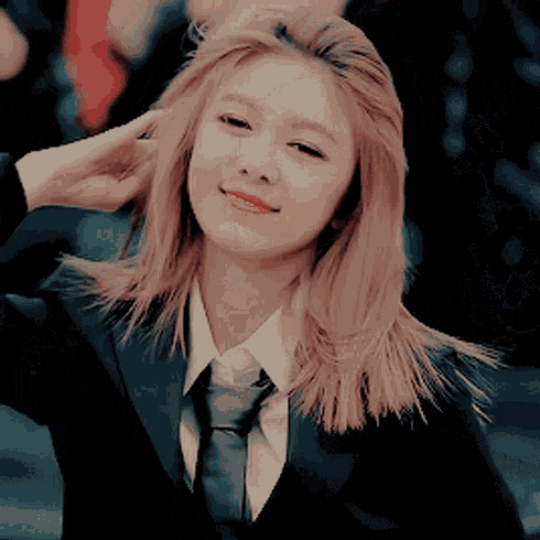 a woman wearing a suit and tie is smiling