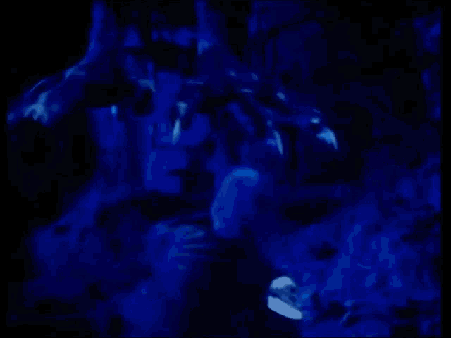 a person is laying on the ground in a dark room with blue lights .