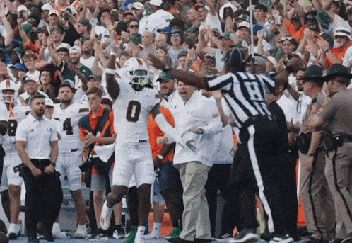 a football player with the number 0 on his jersey celebrates a touchdown