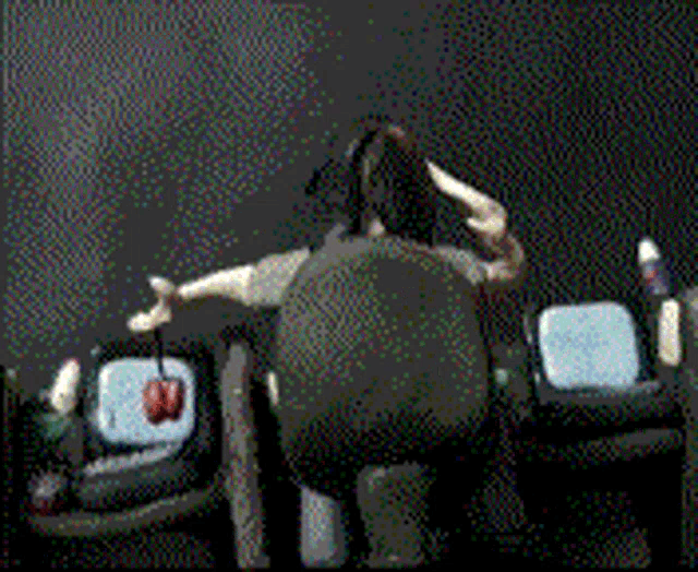 a woman is sitting in a chair in front of a black screen