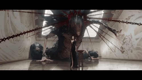 a woman is standing in front of a large monster