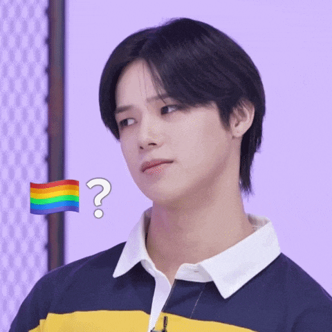 a young man with a rainbow flag and a question mark behind him
