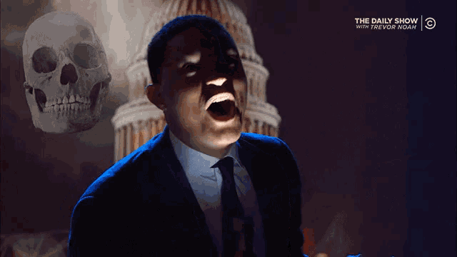a man in a suit and tie screams in front of a skull and the daily show logo