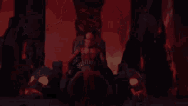 a man with long red hair is sitting on a throne in the dark .