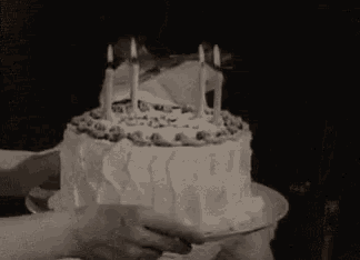 a little girl is blowing out candles on a cake that says happy birthday