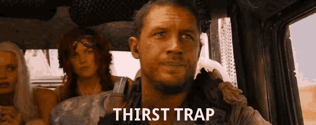 a man is sitting in a car with a group of people and the word thirst trap is on the screen behind him