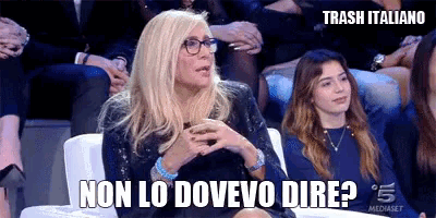a woman wearing glasses is sitting in front of a crowd and says non lo dovevo dire