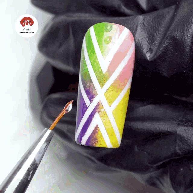 a nail with a rainbow design is being painted by a nail artist