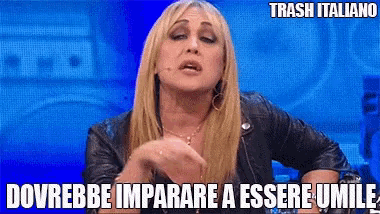 a woman in a leather jacket is talking into a microphone with a caption that says trash italiano