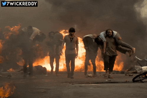 a group of people carrying each other in front of a burning building with the twitter username 7wickreddy