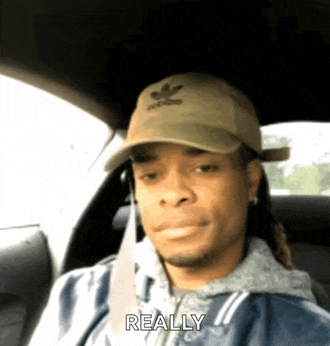a man wearing an adidas hat is sitting in the back seat of a car and says really