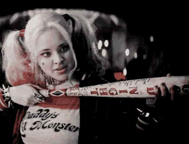 harley quinn is wearing a daddy 's monster shirt and holding a bat