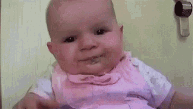a baby is making a funny face while sitting on a couch .