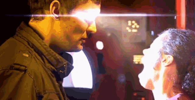 a man and a woman are looking into each other 's eyes with a bright light coming out of their eyes .