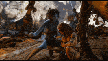 a man with dreadlocks sits next to a woman in a blue bodysuit