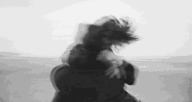 a man is carrying a woman on his back on a beach .