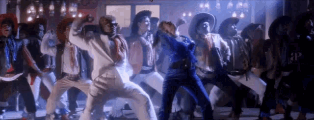 a group of men in cowboy hats are dancing in a dark room .