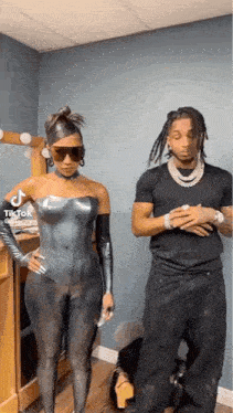 a man and woman are standing next to each other in a room .