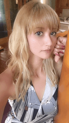 a woman with blonde hair and red nails is leaning against a table