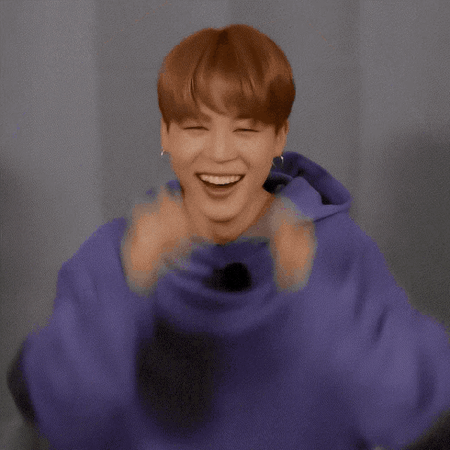 a man wearing a purple sweatshirt with a sticker that says ' i 'm so happy ' on it